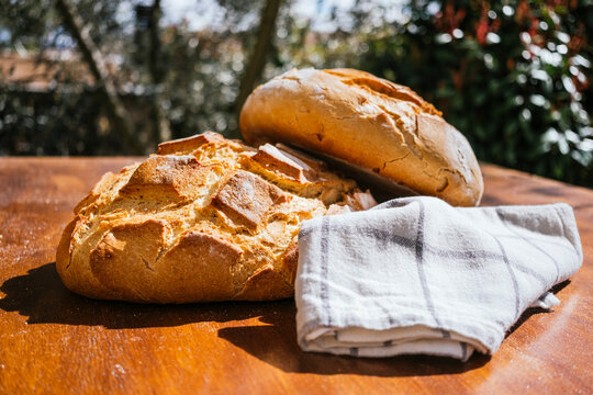 Rustic village bread on a wooden table outdoors