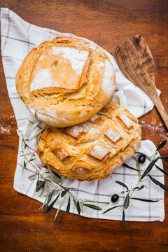 Rustic village bread on wooden table with branches
