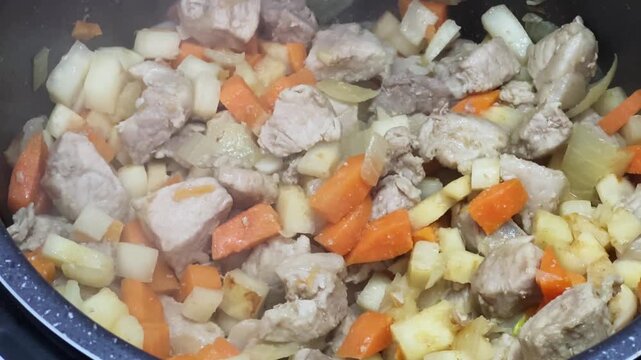Meat with vegetables stewing in multi-cooker during goulash cooking