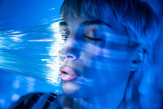 Young woman immersed in metaverse with fiber optics