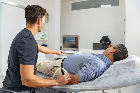 Young physiotherapist performing arm ultrasound with patient