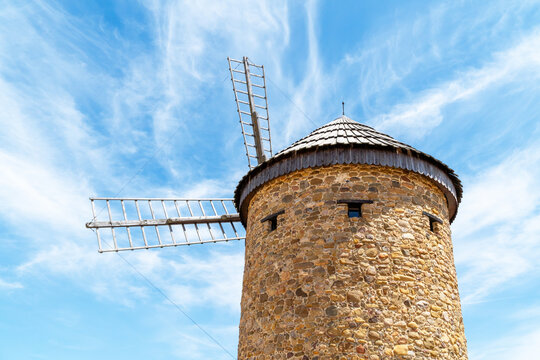 Traditional stone windmill under blue sky for farm energy