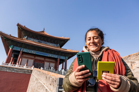 Tourist using audio guide near historical Chinese architecture