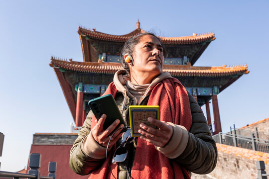Tourist in Beijing listens with audio guide