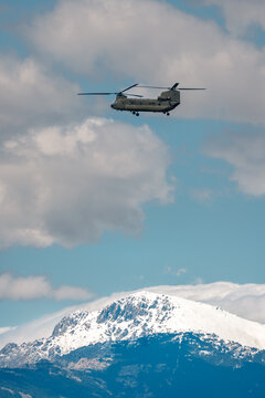 Military transport helicopter over snowy mountain landscape