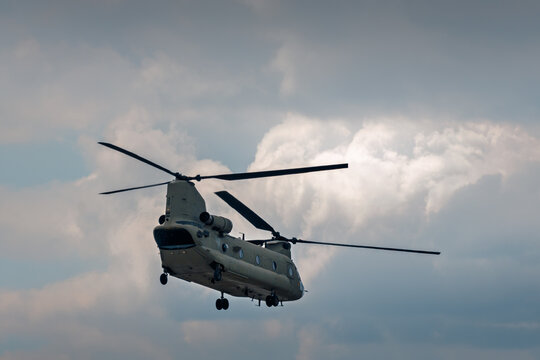 Military transport helicopter flying under cloudy sky