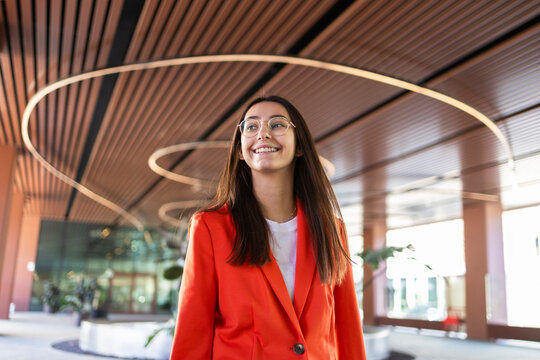 Businesswoman in orange blazer with modern background