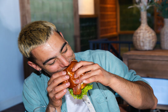 Man enjoying a gourmet burger in a cozy restaurant