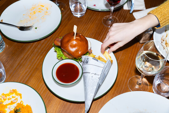 Diner meal with burger, fries and wine on wooden table