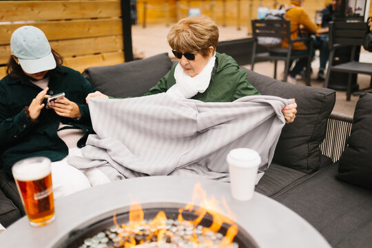 Outdoor cafe seating with warm blanket by fire pit