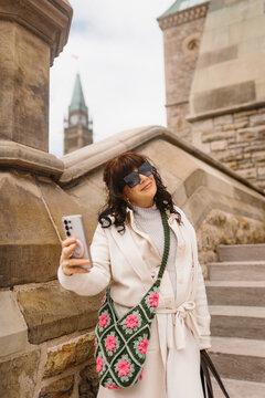 Woman taking selfie on historic stone steps in city