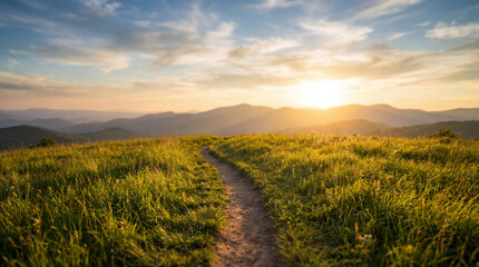 Serene natural landscape with a winding dirt path leading towards a vibrant sunset over rolling mountains. © mark