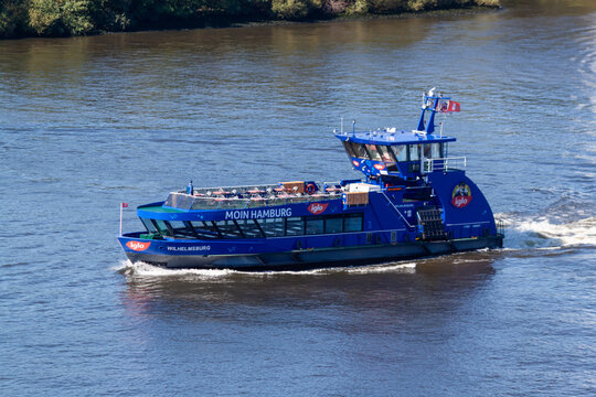 HADAG ferry "Wilhelmsburg" with "Moin Hamburg" and "Iglo" branding cruising on the Elbe River. Modern passenger water transport in the Port of Hamburg, Germany