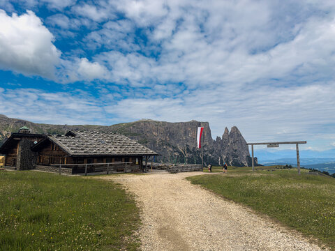 Hiking path and mountain hut in front of the Schlern on the Seiser Alm in the Dolomites, South Tyrol, Italy.