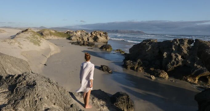 teenage girl overlooking beautiful rocky coastline, Sopies Klip, Hermanus, South Africa