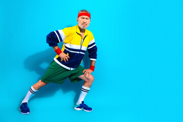 Obraz premium Active senior man stretching in retro sportswear and headband for fitness and workout concept