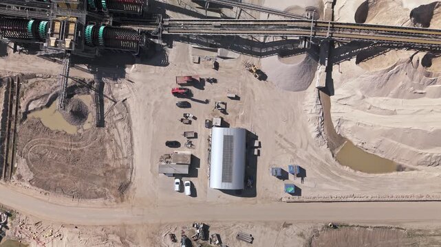 Top-down aerial view of active sand quarry and processing plant revealing lake