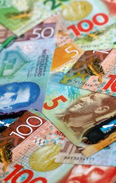 New Zealand dollar money bills pile on table. New Zealand banknotes of NZD currency close up.