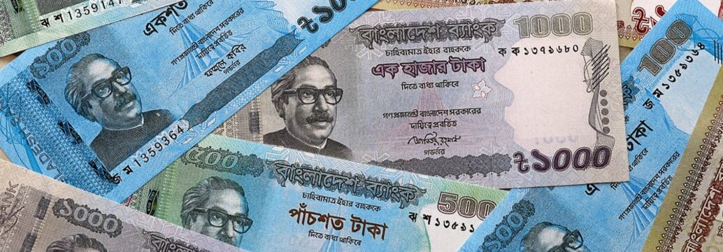Bangladeshi taka money bills pile on table. Bangladesh banknotes of BDT currency close up.