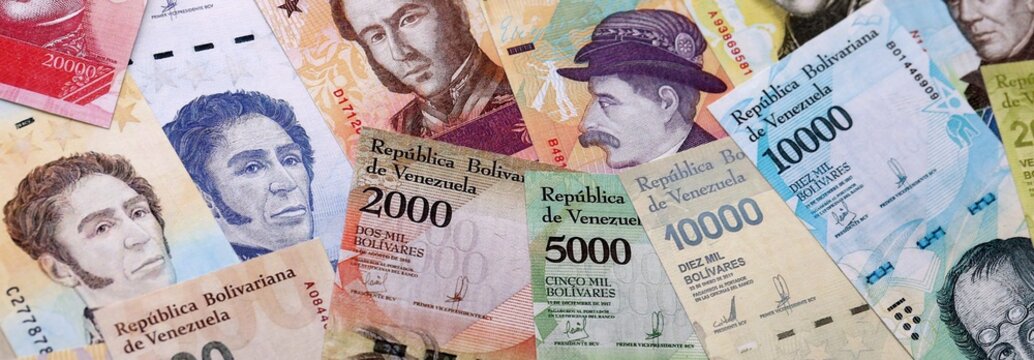 Venezuelan bolivar money bills pile on table. Venezuela banknotes of VES currency close up.