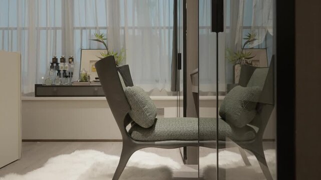 Modern minimalist interior featuring a single armchair beside a windowsill with decorative items and soft natural lighting