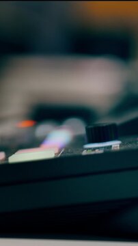 turning knob audio mixer equipment. Music producer adjusting sound levels professional MIDI controller hardware interface. Closeup view vertical video frame electronic music production