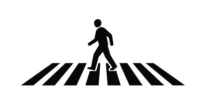 Silhouette of a person walking across a pedestrian crosswalk