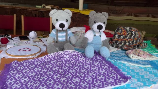 Zoom in shot of two crocheted teddy bears and traditional embroidery from Vlkolinec UNESCO village, Slovakia