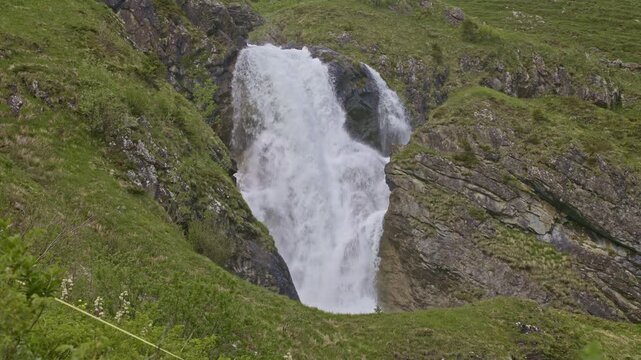 A mountain waterfall with water cascading down from rocky cliffs. Staeuberfall waterfall, Switzerland.