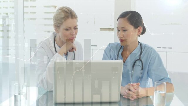Left doctor leaning, pointing and speaking, nurse turning and reviewing charts on laptop for health