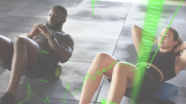 Fitness duo starting reclined crunching on foam rollers, green overlay showing metrics for tracking