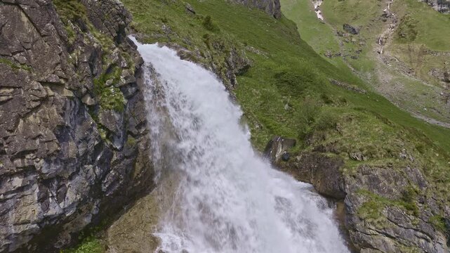 A mountain waterfall with water cascading down from rocky cliffs. Staeuberfall waterfall, Switzerland.