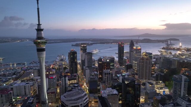 Dolly Flight through Auckland , New Zealand. Skyline. New Skyscrapers. Urban Canyon in Sunset or Sunrise Light. Aerial Pedestal in Establishing Night Drone Shot. Glowing street lights