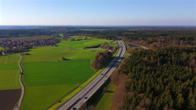 Birds eye view of the A95 asphalt road and public infrastructure in Germany. The motorway serves as a main bypass and connection for logistics and travel in the Munich district.