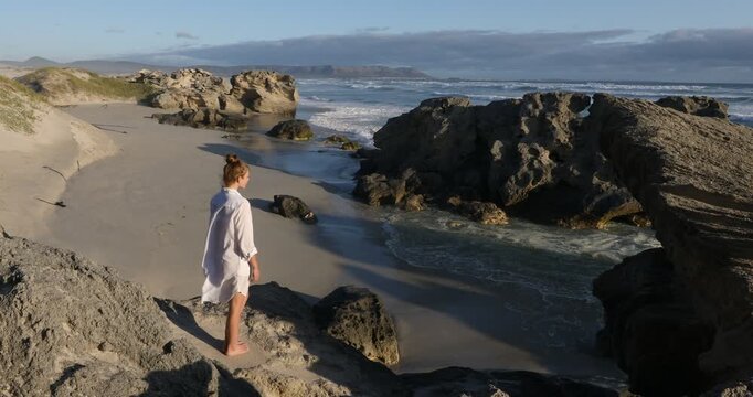 teenage girl overlooking beautiful rocky coastline, Sopies Klip, Hermanus, South Africa