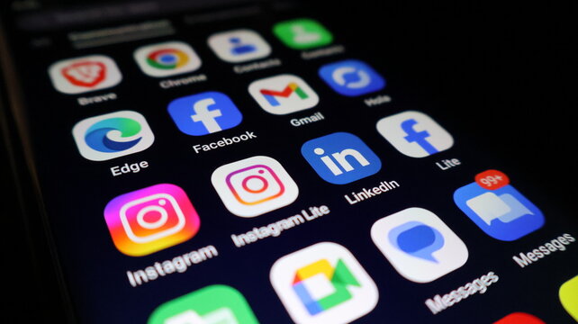 A smartphone screen displays various social media apps in a modern digital landscape
