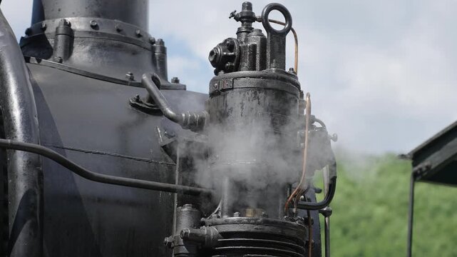 Close up of mechanical steaming details, wheels and piston of a vintage steam engine. Historic locomotive, industrial heritage, 4K, ProRes, 50fps.