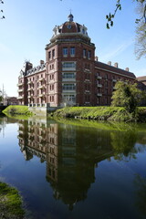 Fototapeta premium Grand bâtiment victorien reflété dans le canal, le familistère Godin, Guise, A large Victorian building reflected in the canal, the Godin Familistère, Guise
