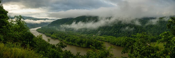 Obraz premium Low Rain Clouds Hang Over The Slow Moving River In New River Gorge