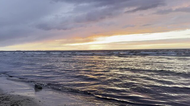 Golden sunset over ocean pier with waves