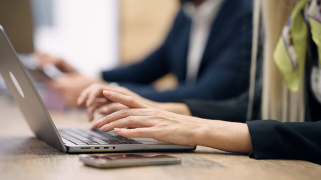 Professional woman's hands typing on a laptop keyboard during a business meeting, focusing on work and productivity