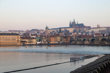 Fototapeta premium scenic view of Prague Castle and Charles Bridge glowing in golden light over the Vltava River