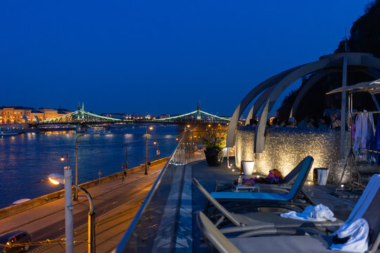 BUDAPEST, HUNGARY - MARCH 10, 2026: Unidentified people enjoying rooftop thermal pool at night in Budapest. Rudas Thermal Bath and Spa over Danube River