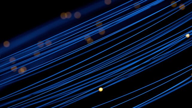 Seamless loop of glowing yellow particles traveling along blue fiber optic lines. Represents high-speed connectivity, cloud computing. Ideal for tech backgrounds, corporate videos, futuristic concepts