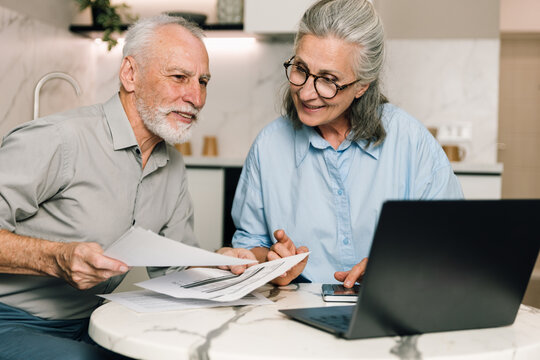 Couple reviews utility bills and expenses together while using laptop at home