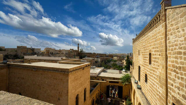 Historic stone architecture in Midyat, Mardin, showcasing traditional Middle Eastern and Anatolian design under blue sky