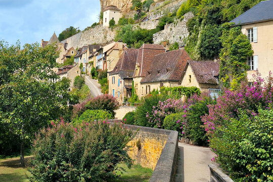 View to the village of Beynac-et-Cazenac, Dordogne, France from a flower lined walkway