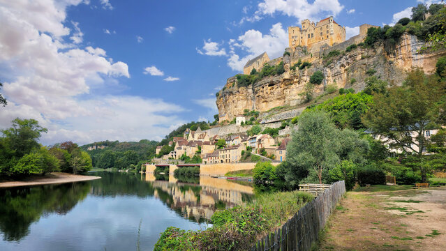 View to the beautiful French village and castle of Beynac-et-Cazenac and the Dordogne River from the river side walkway during summer