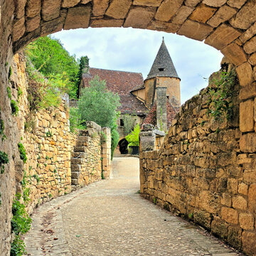 Beautiful arched street in the village of La Roque-Gageac, Dordogne, France with medieval turreted stone architecture