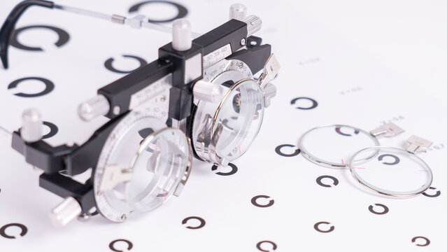 Black phoropter device features two round lenses and adjustable knobs